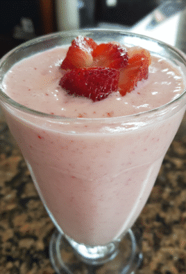Smoothie King Strawberry Yogurt Delight in a tall glass with mint and strawberry garnish.