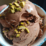 Chocolate and pistachio ice cream with a creamy texture and crunchy pistachios on top.