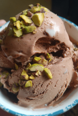 Chocolate and pistachio ice cream with a creamy texture and crunchy pistachios on top.