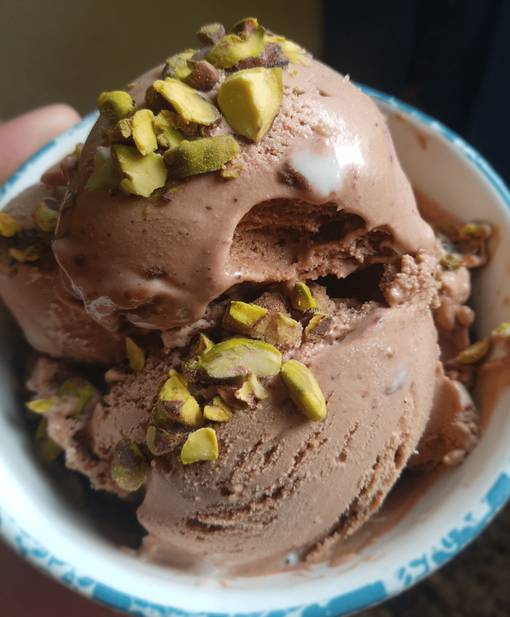 Chocolate and pistachio ice cream with a creamy texture and crunchy pistachios on top.