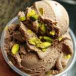 Ingredients for chocolate and pistachio ice cream including heavy cream, milk, cocoa powder, and pistachios.